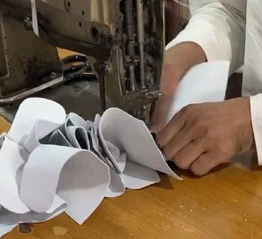Hands stitching glove components at our manufacturing facility